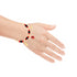 A hand adorned with a Red and Black Evil Eye, Figa Hand, and Elephant Lucky Charm bracelet, adjustable and gold-filled, elegantly displays its intricate design of black beads, red accents, and a dangling evil eye charm against a plain white background. The fingers are relaxed and slightly spread apart.